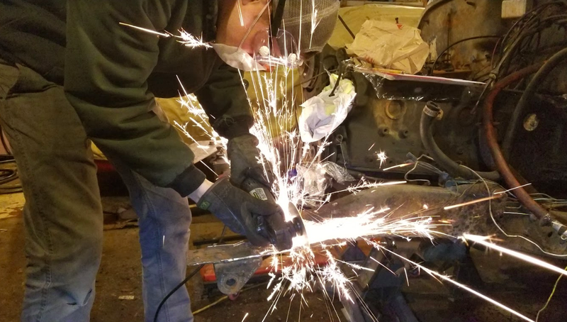My friend Mike wearing the proper safety equipment while using an angle grinder to cut my frame.